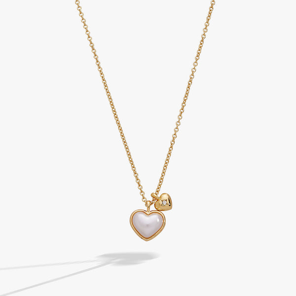 Gold necklace with a heart-shaped pendant on a white background